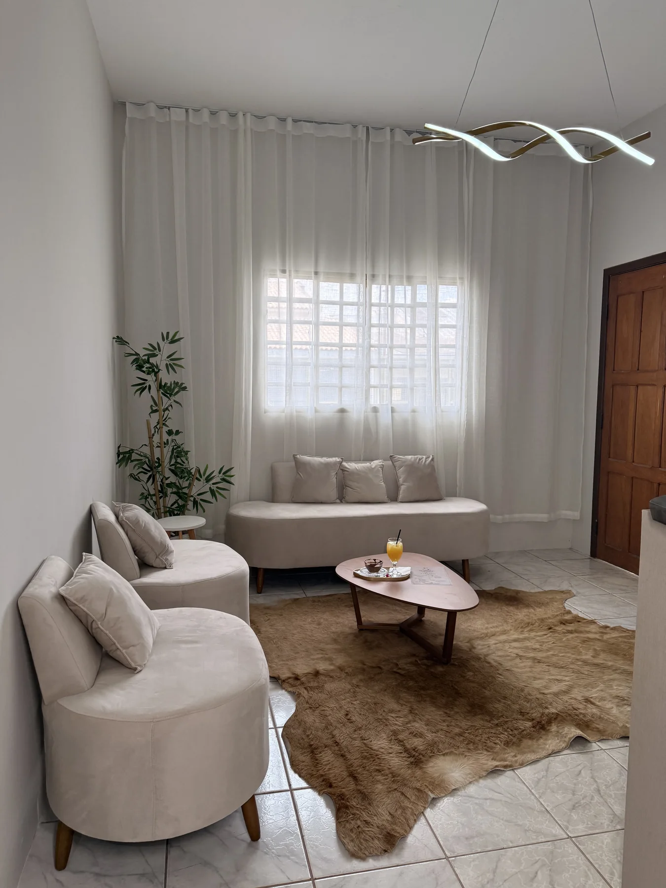Recepção real da Clínica Salute com poltronas claras e cortinas brancas
